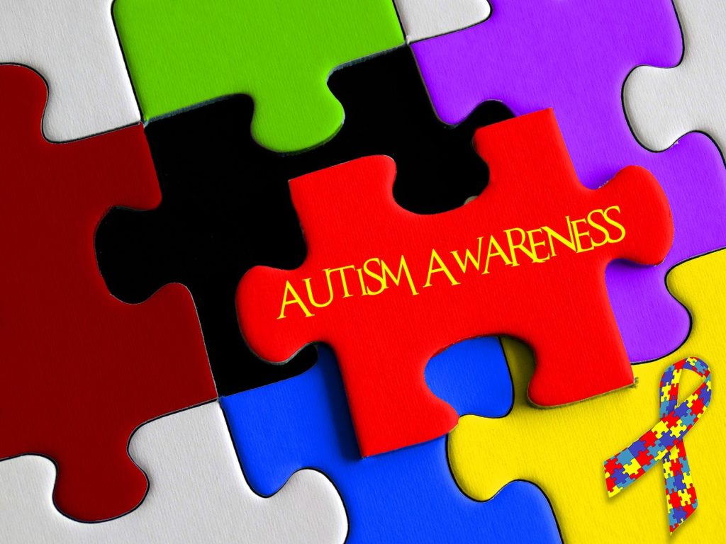 A piece of puzzle board with 'Autism Awareness' written on it