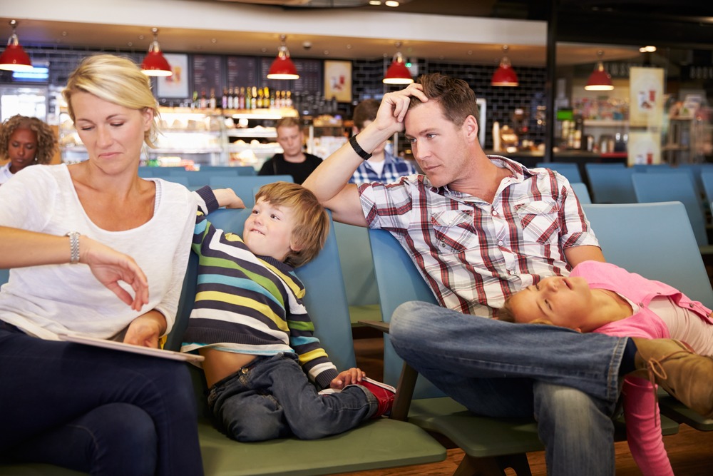 Mother looking at the watch and dad and son losing patience waiting for flight