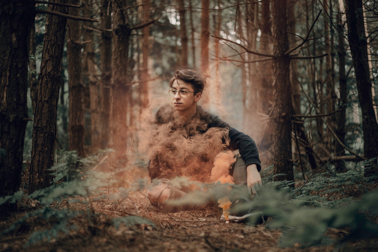 a kid with teen age depression sitting in the woods