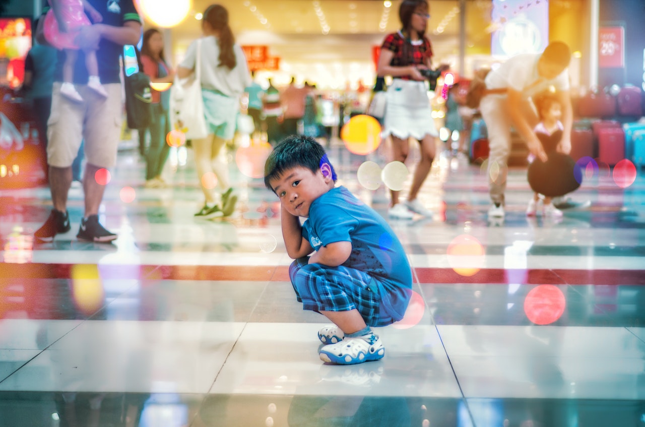 Child upset and squatting on the shopping mall floor